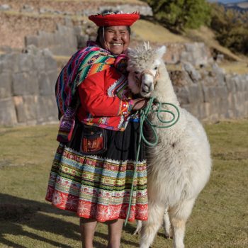 Cuzco, Peru - July 14, 2018. Peruvian woman dressed in traditional colourful clothes with alpaca / llama at Sacsayhuaman, Cusco, Peru, South America.